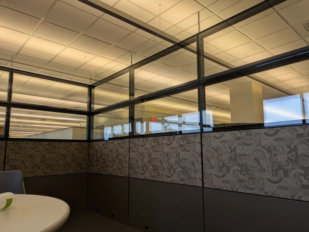 Open office glass partitions with a patterned decorative film band along the lower panels