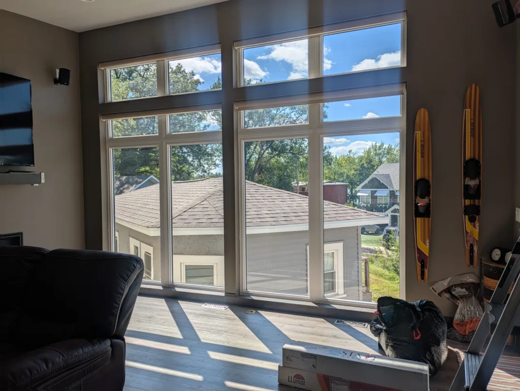 Living room with a two-story wall of windows treated with clear window film for sun and glare