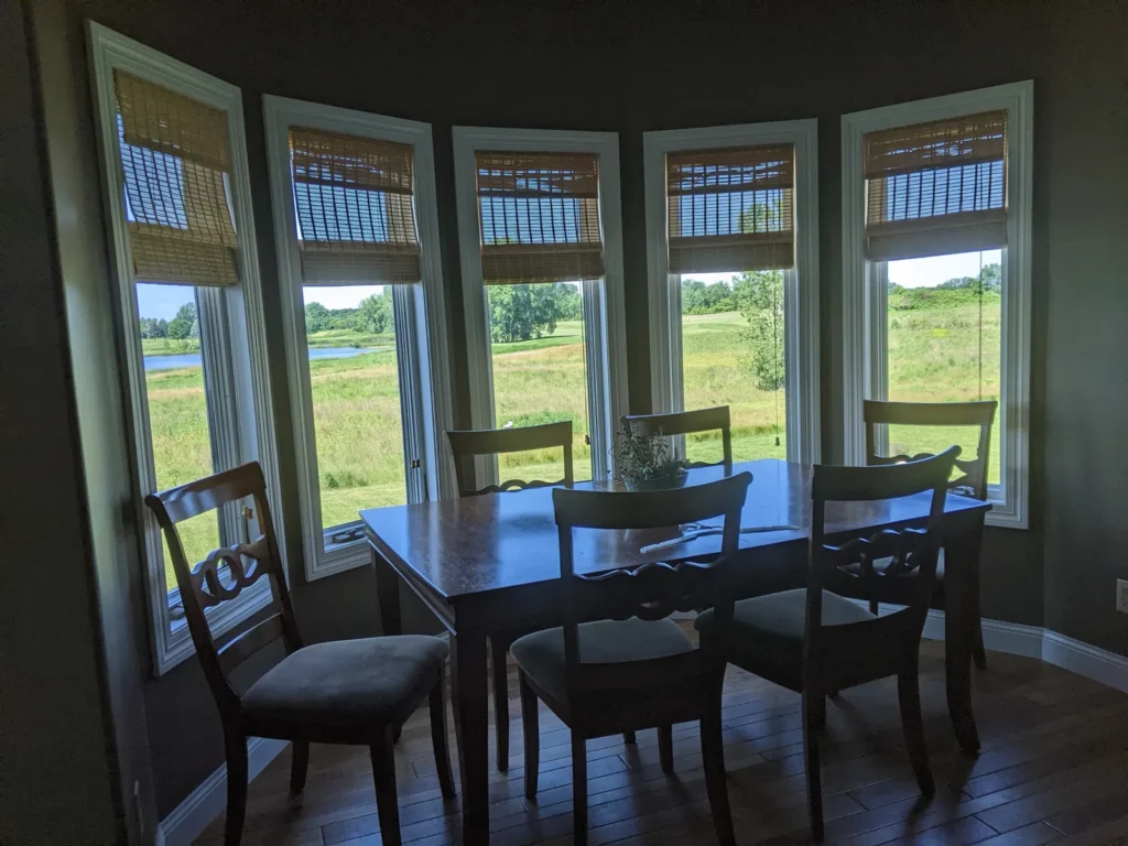 Dining room bay windows with solar control window film, looking out over a pond and open field