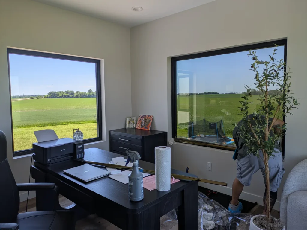 Home office with large picture windows getting solar window film while keeping the open field views