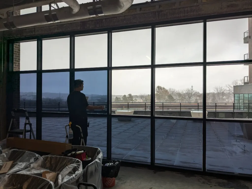 Window wall partly covered with one-way mirror film, showing filmed and unfilmed glass side by side
